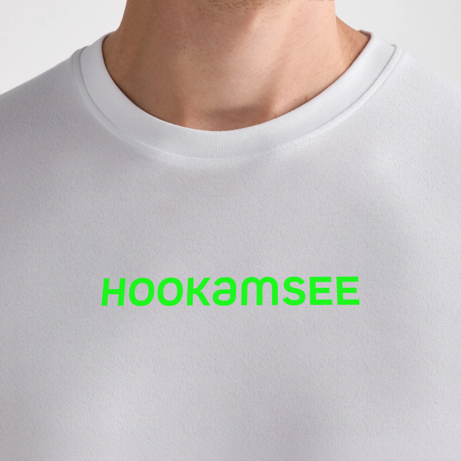 Neongrünes HOOKamSEE Logo auf weißem T-Shirt