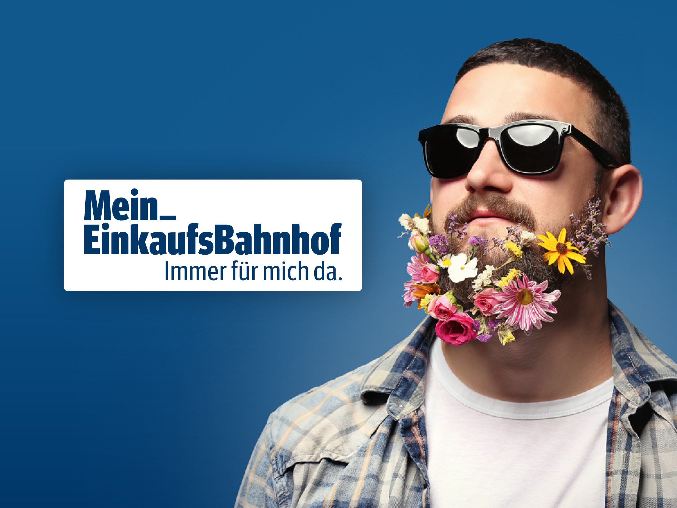 Mein EinkaufsBahnhof Logo, Mann mit Sonnenbrille und Blumen im Bart auf blauem Hintergrund