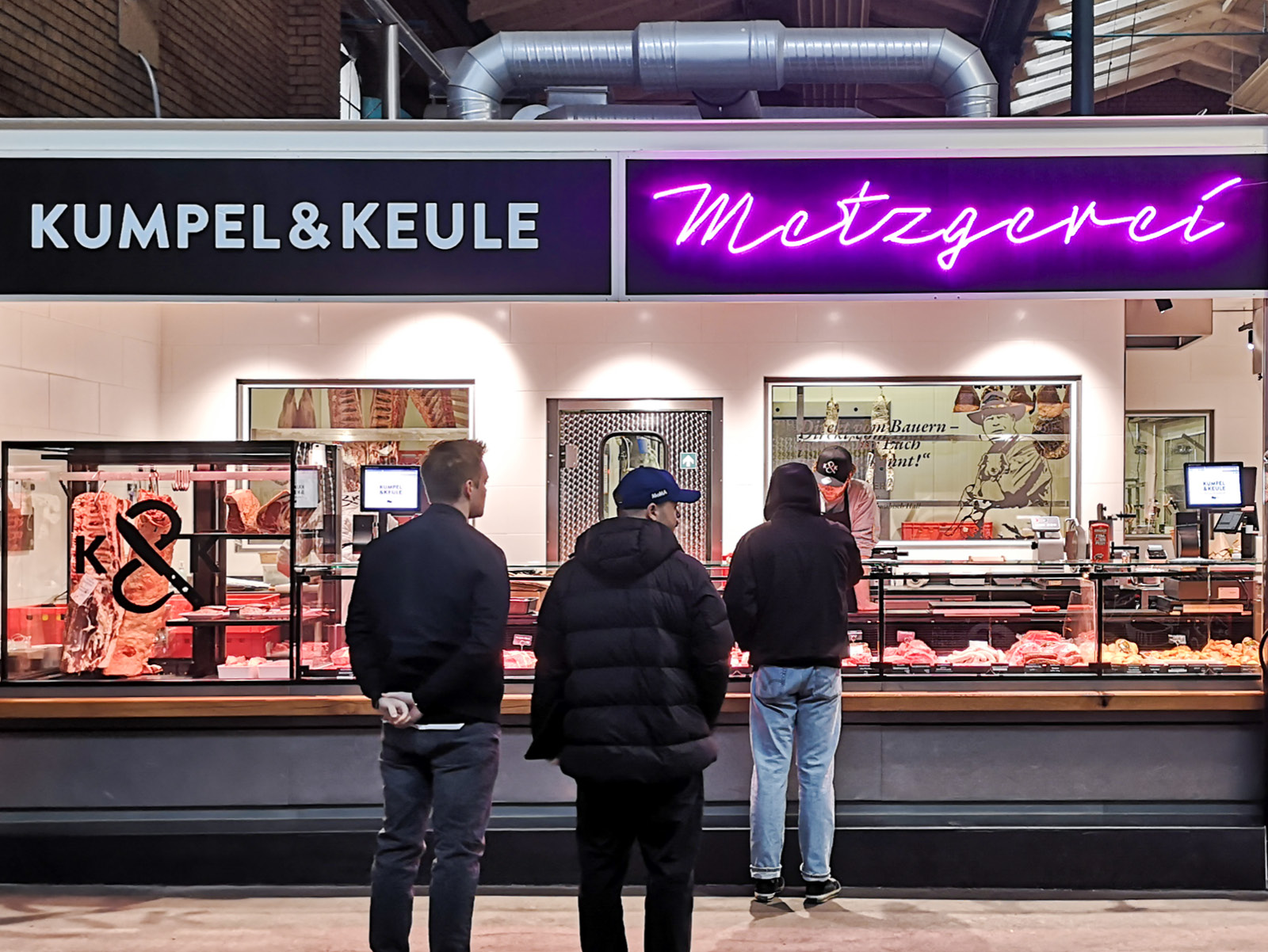 Menschen stehen an der Metzgerei-Theke von Kumpel & Keule