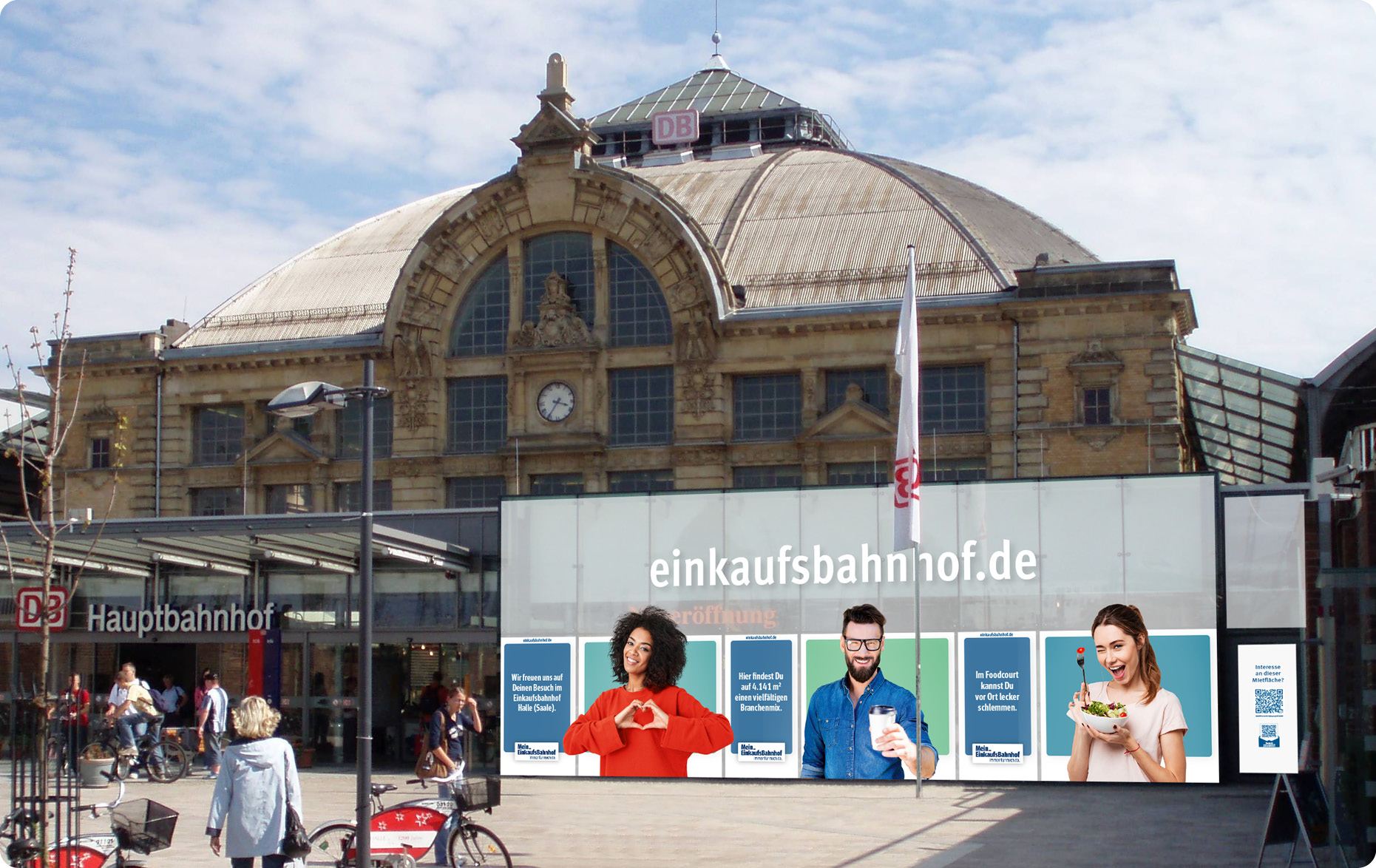 Blick auf eine Bahnhofsfassade mit Mein Einkaufsbahnhof Kampagnenmotiven als großflächige Fensterbeklebung