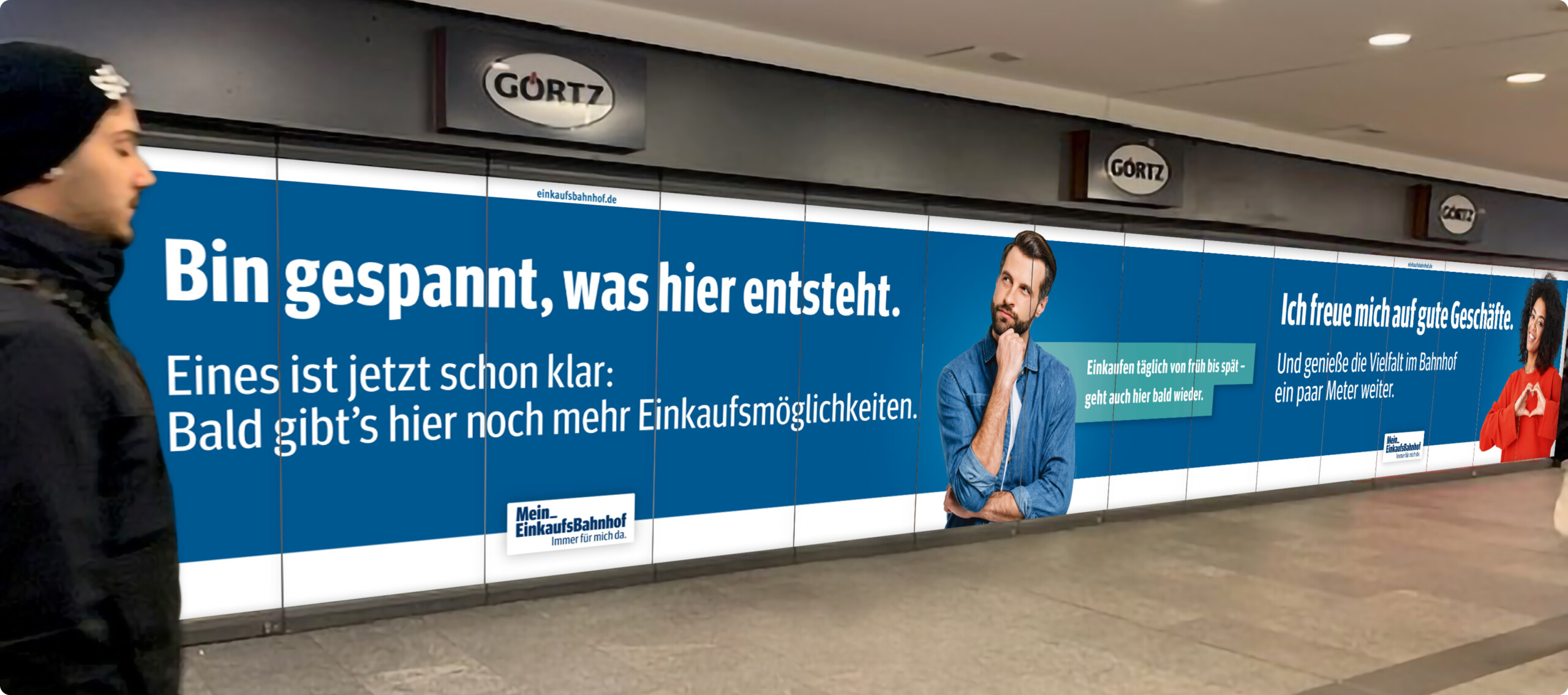 Schaufensterbeklebung mit Kampagnenmotiven und weißem Text auf blauem Untergrund: Bin gespannt, was hier entsteht.